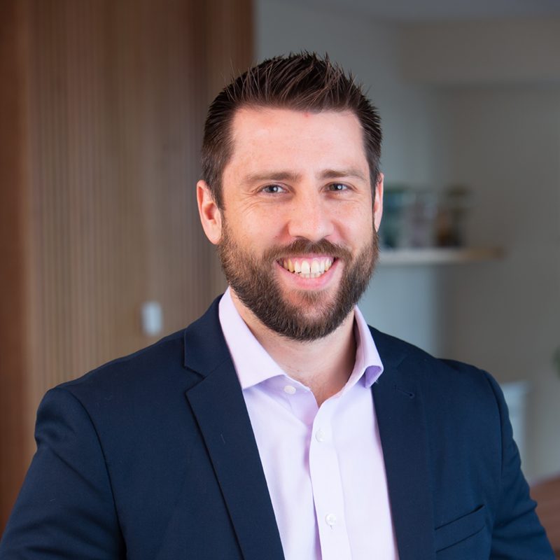 Professional front on, close up image of Director and commercial property specialist Cameron Scott smiling.